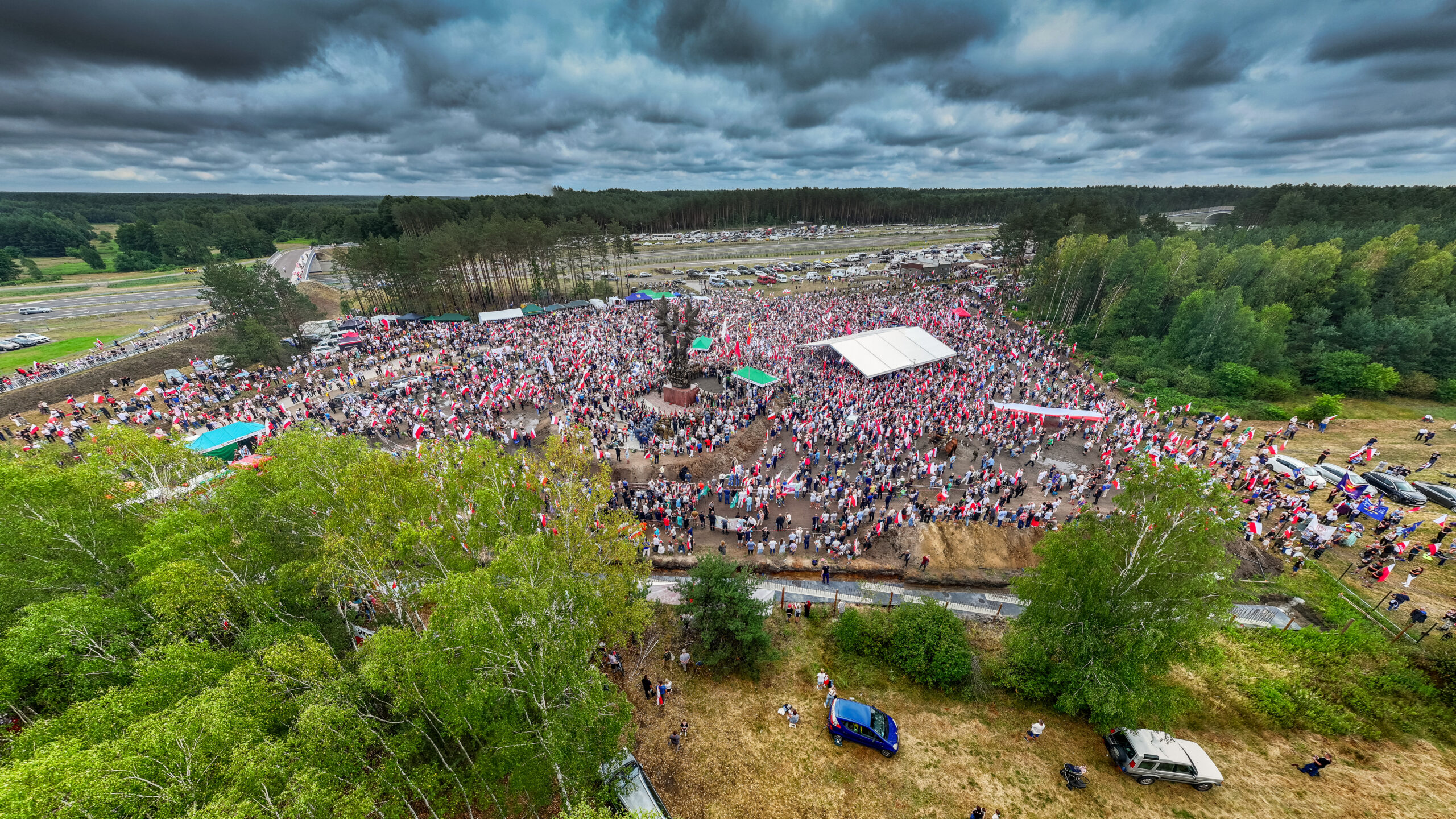 Uroczystość odsłonięcia pomnika "Rzeź Wołyńska" w Domostawie, 14 lipca 2024. Widok z drona na tłum zgromadzony wokół monumentu, fot. Marcin Żołna